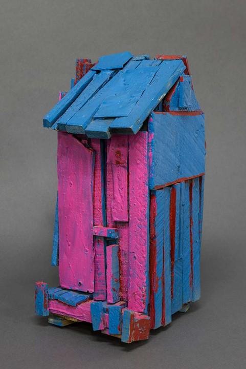 small sculpture of a run-down shack painted in bright blue and pink