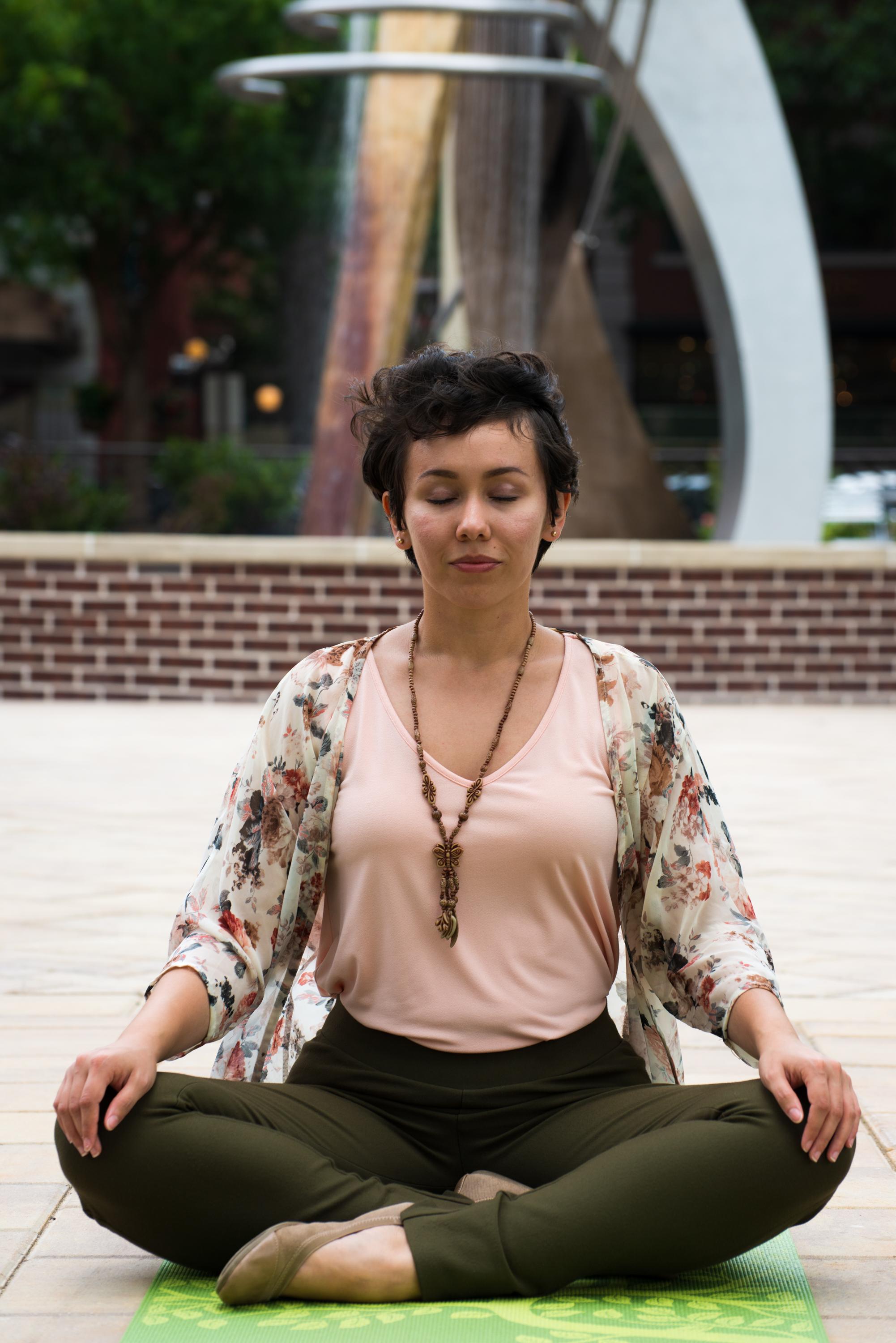 Elizabeth Houck-Zozaya in a seated yoga pose on boyd plaza