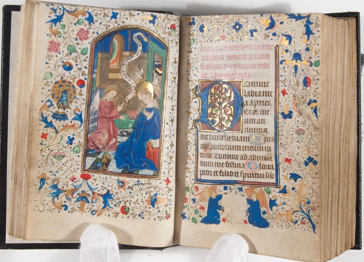 The very ornate Book of Hours held open to show both text and illustration pages