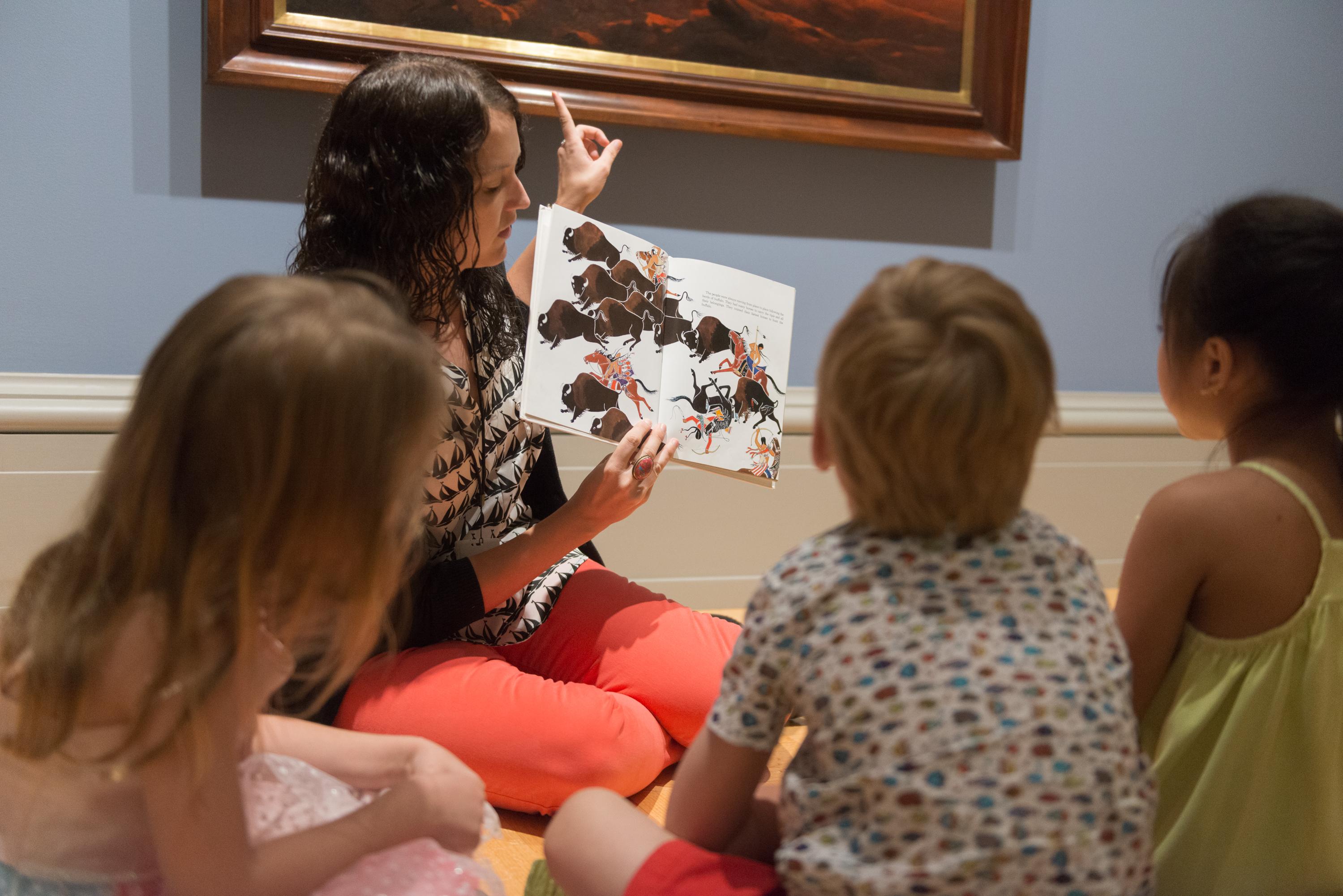 children look at art in the galleries while hearing a story