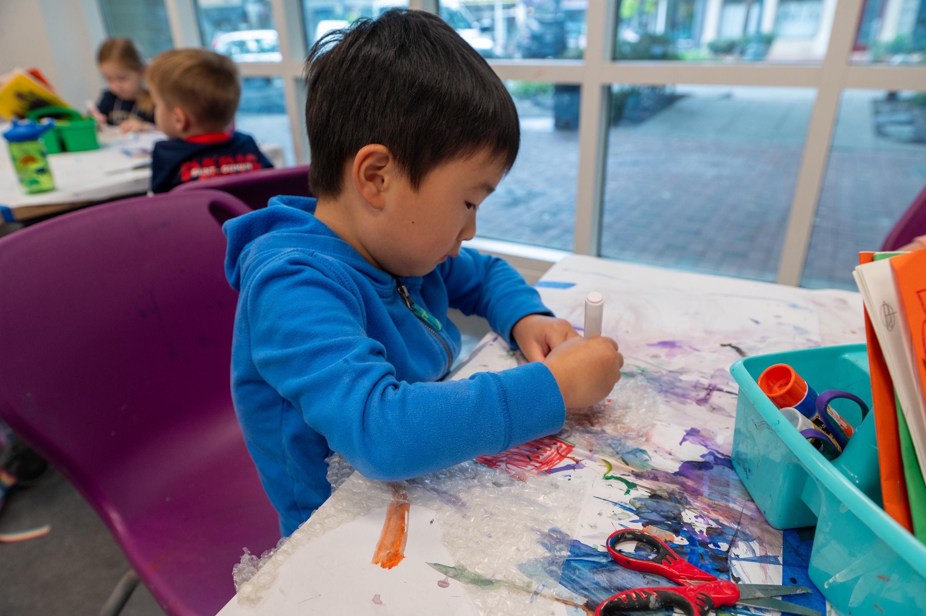 a young boy makes art in the studio